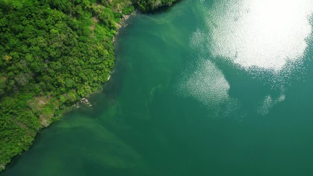 Pullback aerial reveal of tropical mountain terrain and coastal clear and clean waters in Cuenca Batangas Philippines featuring Mt Maculot and Labangan Bay.