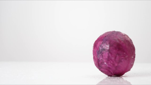 Vibrant Purple Cabbage spinning on a white backdrop in extreme slow motion 800fps high speed.
