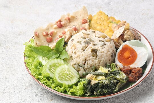 Nasi Megono, a signature dish from Central Java, Indonesia, featuring steamed rice topped with finely chopped young jackfruit mixed with grated coconut and aromatic spices
