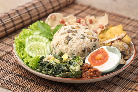 Nasi Megono, a signature dish from Central Java, Indonesia, featuring steamed rice topped with finely chopped young jackfruit mixed with grated coconut and aromatic spices