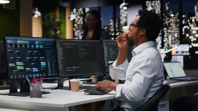 Programmer stretching back at office desk while developing machine learning models to automate tasks with coding and programming workflow.
