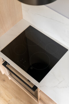 Modern minimalist kitchen with sleek induction hob and marble counter