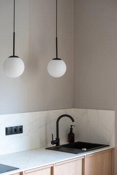 Modern kitchen interior with black sink, faucet, and wooden cabinetry