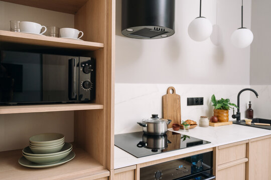 Kitchen interior with built-in microwave, stove and cooker hood