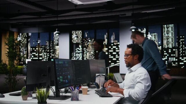 Programmer stretching back at office desk while developing machine learning models to automate tasks. Fatigued developer relaxing limbs in chair, writing programming language scripts on PC.