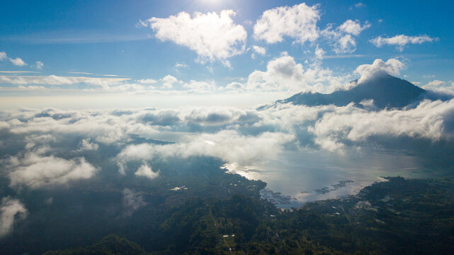 Aerial morning view of Lake Batur and Mount Abang shrouded in thick clouds, Kintamani, Bali, Indonesia.