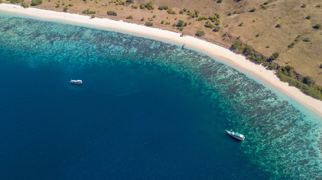 Aerial View of Boats Floating near a Tropical White Sand Beach and Coral Reef