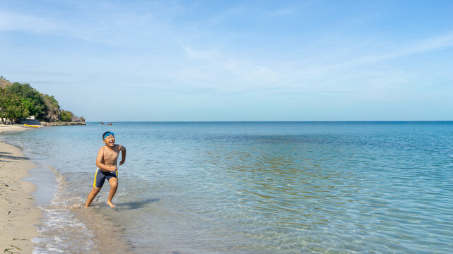 Happy Boy Running and Splashing on Sunny Tropical Beach Shore