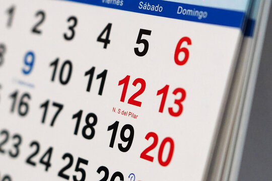 Close-up of October 2024 desk calendar highlighting day of '12 de Octubre, N. S del Pilar' and weekends in red.