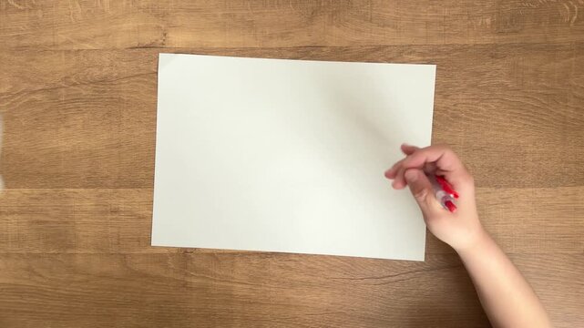 Child Hand Clicking a Red Ballpoint Pen to Start Writing, Top Down View, 4K Silent Video