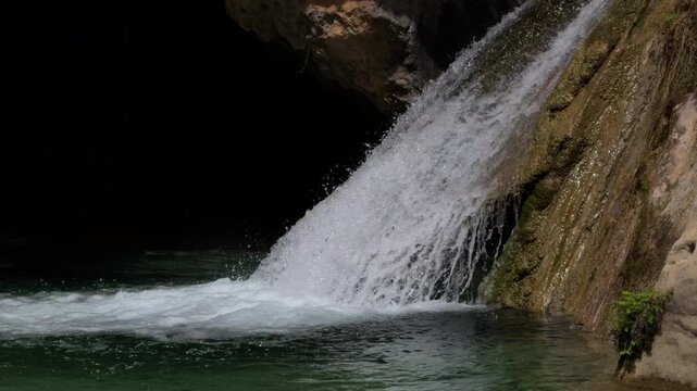 Slow Motion Waterfall Cascading Over Rugged Rock and Moss