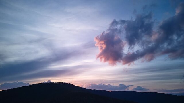 Aerial Hyperlapse at Dawn with Dramatic Pink Cloud Over Forest Hill Silhouette
