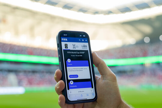 MINSK, BELARUS JUNE 9, 2026: Man holding a purple Apple iPhone 14 Pro in the stadium. The official FIFA website selling tickets for the 2026 FIFA World Cup in the USA, Mexico, Canada.