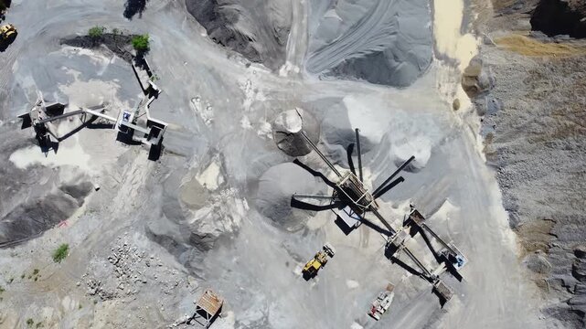 Drone view of industrial quarry with rock crushing and screening machinery. Industrial mining quarry seen from above. Extraction site. Mining quarry.