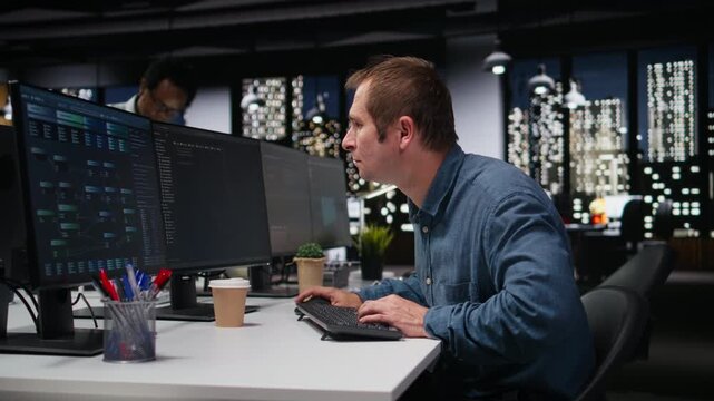Software developer in office typing code on computer, developing machine learning models to automate tasks with coding and programming workflow.