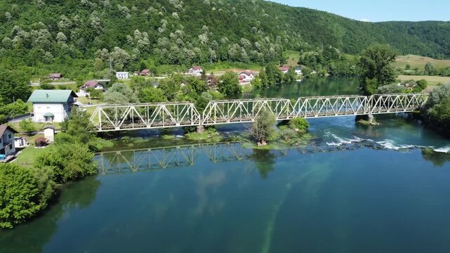 Aerial drone view of railway bridge crossing a river. Train bridge over flowing clean river.