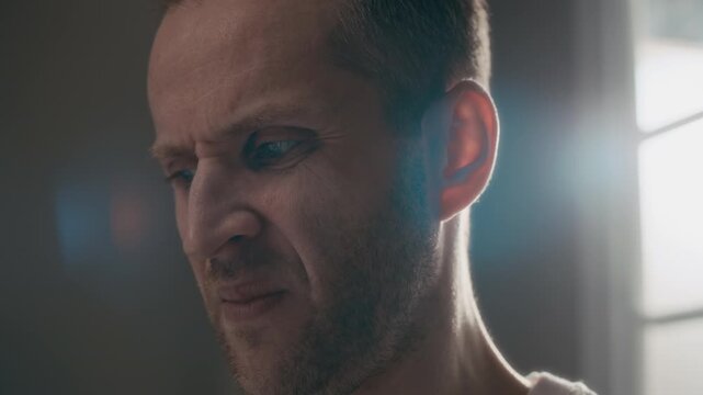 Closeup of Caucasian man in psychiatric clinic grimacing and rejecting pill on tongue. Footage is perfect for mental health awareness campaigns and medical documentaries on patient care