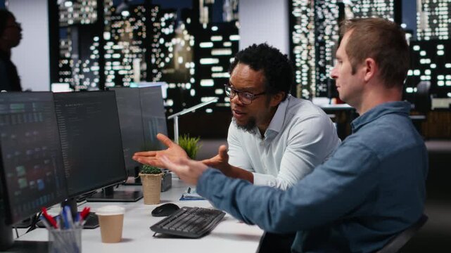 Team of technicians collaborating in office, typing code on computer, developing machine learning models to automate tasks. Employees work together write programming language scripts on PC.