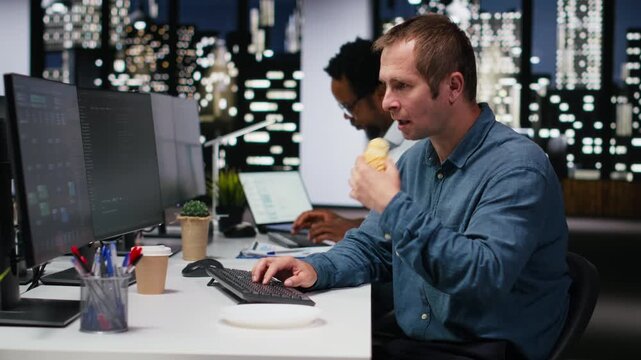 Technician eating croissant in office, developing apps with AI. IT expert consuming snack while using machine learning to do coding, debugging apps.