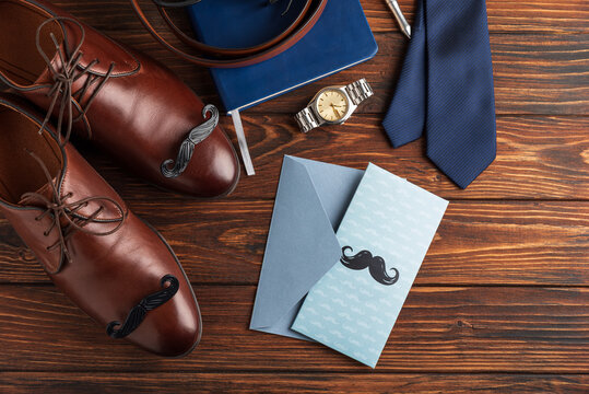  Father's Day concept with shoes, tie, watch, and greeting card on wood surface
