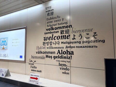 New Chitose Airport arrival area featuring a multilingual welcome wall display with greetings in various international languages in Sapporo - Hokkaido, Japan, May 09, 2026
