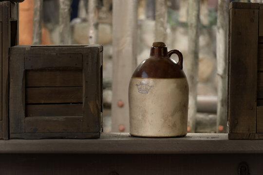 Vintage moonshine stoneware jug on rustic shelf