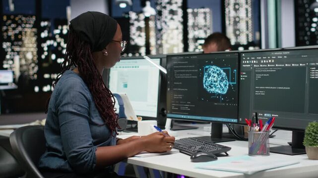Programmer taking notes at desk in Silicon Valley company office, developing apps. IT expert using machine learning to do coding, writing on notepad, debugging applications to resolve issues.