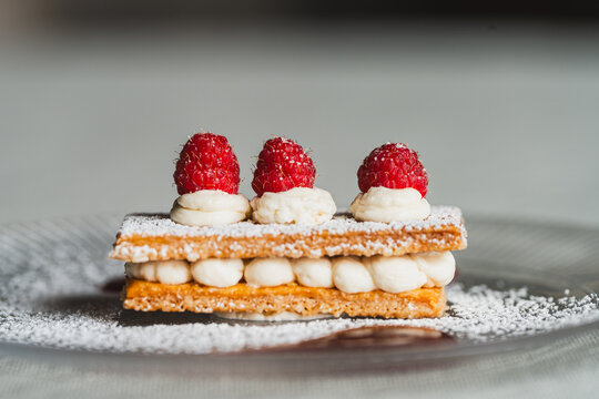 postre de milhojas de nata, az&uacute;car glas y moras rojas
