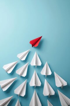 One red paper plane leading a group of white paper planes in a conceptual business leadership concept