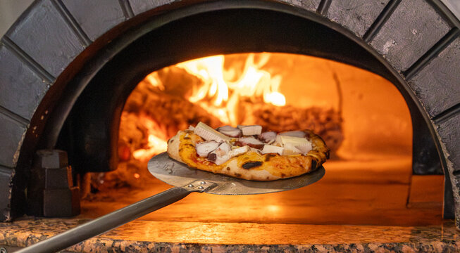 Pizza entrando a horno de le&ntilde;a