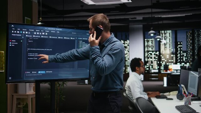 Silicon Valley company manager office making phone call, developing apps. Team leader calling employees to debug applications and resolve issues, supervising progress for coding workflows.