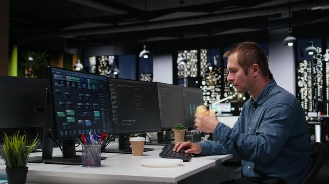 Technician eating croissant in company office, developing apps with AI. IT expert consuming snack while using machine learning to do coding, debugging applications to resolve issues.