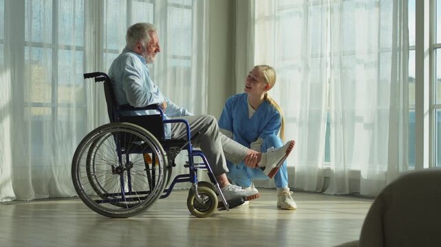 Help support retirement healthcare. Nurse helping old man in wheelchair. Patient and woman in nursing home for medical caregiver. Nurse taking care of paralyzed man in chair for people with disability
