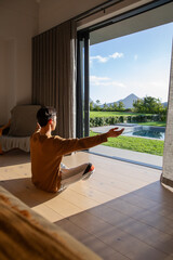 Naklejka premium Sunlight is streaming through open sliding glass door onto wooden plank floor, casting long shadows