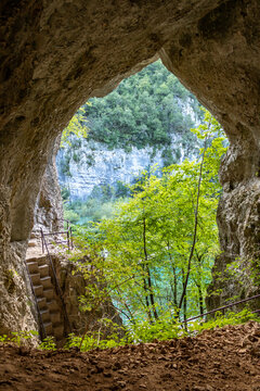 View of a turquoise lake through a cave opening in Plitvice Lakes National Park, Croatia