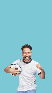 soccer fan with soccer ball in hand celebrating on isolated free background. Vertical panorama with copy space.