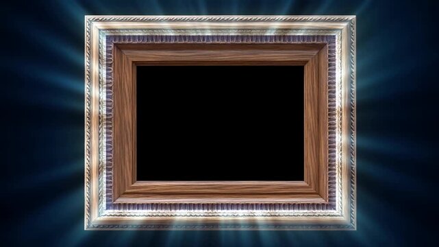 Slow zoom dolly of ornate wooden picture frame glowing and sparkling with radiating light over dark studio backdrop with spotlighted empty center
