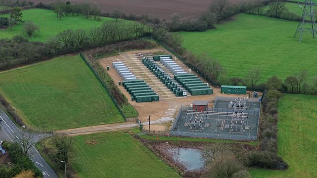 High angle aerial view of green energy grid stabilization infrastructure and electrical substation transformers UK