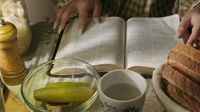 young conservative asian Woman Reading the Bible at table with bread food and drink indoors