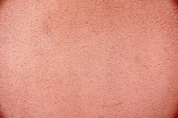 Fototapeta premium Peach-colored granular stucco wall texture.