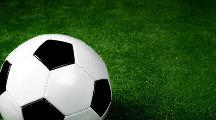 Fototapeta premium Soccer ball on a vibrant artificial grass background, representing sport and competition.