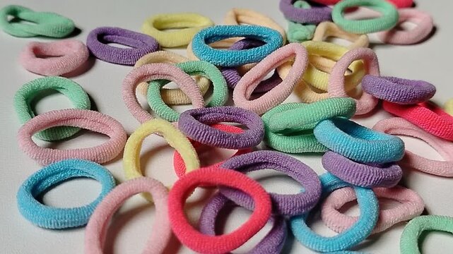 Assorted colorful hair bands isolated on a white background in closeup. Simple and practical hair accessories featuring vibrant colors, suitable for beauty, lifestyle, personal care, and fashion indus