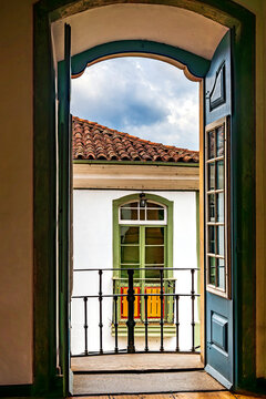 View through a balcony and window of the historic city of Ouro Preto and its typical architecture.