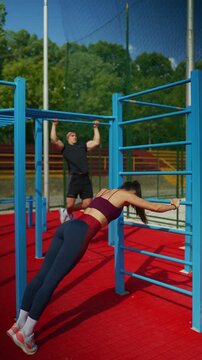 An athletic performs a calisthenics workout at an outdoor sport park. They demonstrate physical exercise and training for a healthy, active lifestyle.