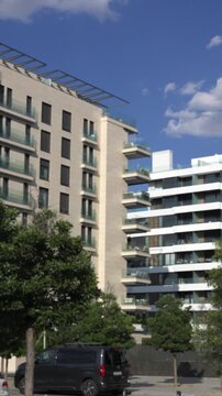 Tall residential buildings with balconies and green trees in front