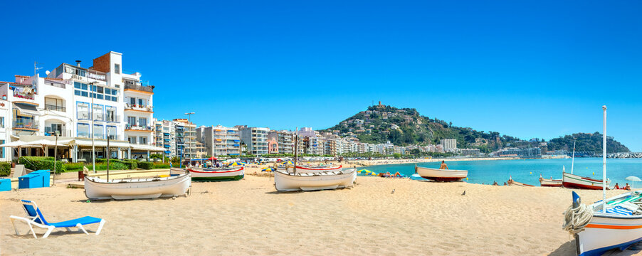 Panoramic view of sandy beach with fishing boats in Blanes town. Costa Brava, Catalonia, Spain
