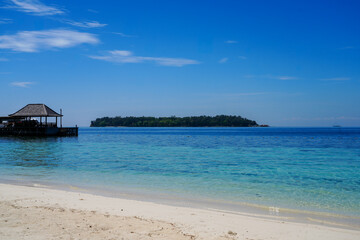 Fototapeta premium Beautiful tropical beach with a wooden jetty and crystal clear turquoise sea at Sepa Island resort, Thousand Islands, Jakarta, Indonesia.