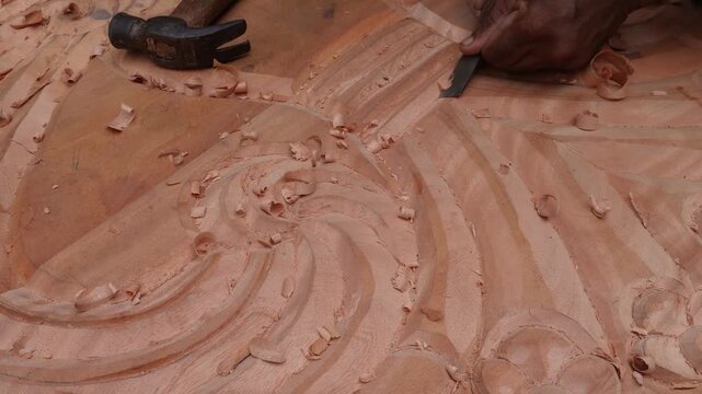 Artisan carving intricate wood patterns by hand