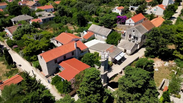 The iconic Toreta tower on Silba Island, Croatia, a historic stone landmark featuring its famous external spiral staircase. The shot captures the architectural beauty and unique character of this