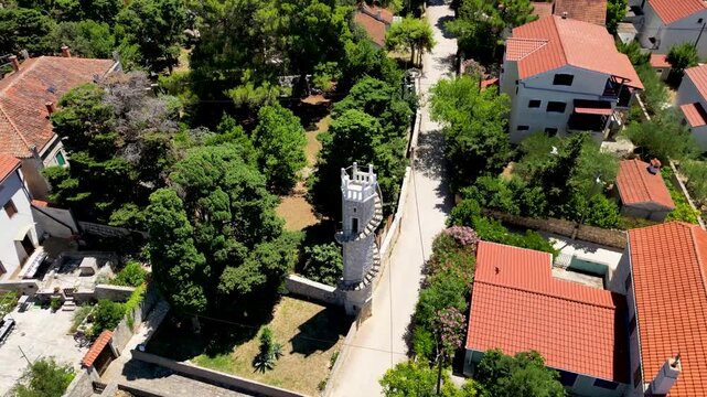 The iconic Toreta tower on Silba Island, Croatia, a historic stone landmark featuring its famous external spiral staircase. The shot captures the architectural beauty and unique character of this